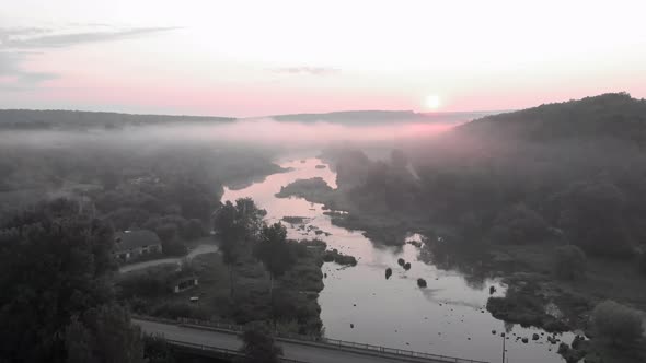 Aerial drone view of sunrise over misty river