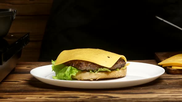 Closeup of the Hands of the Chef Put Various Ingredients Alternately on the Bun for an Appetizing