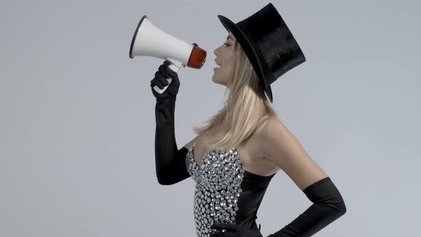 Young Woman Wearing Black Top Hat and Fishnets Using Megaphone