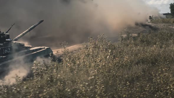 Tanks Move Across Field Gray Dust From Sandy Road