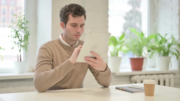 Man Using Tablet While Sitting in Office