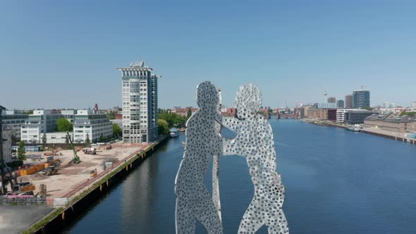 Backwards Reveal of Molecule Man Sculpture in Spree River and Various Buildings Surrounding Calm