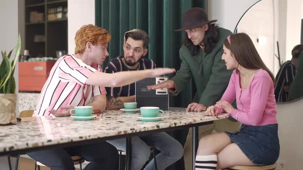 Young Friends Stacking Hands in Retro Coffee Bar Smiling