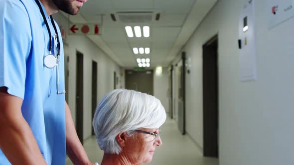 Nurse carrying female senior patient with wheel chair