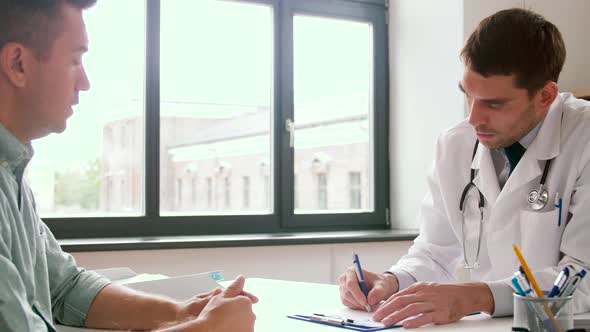 Doctor Writing Prescription for Patient at Clinic 53