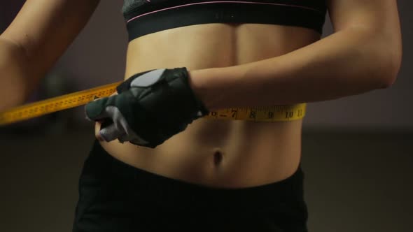 Female Athlete Measuring Waist, Checking Results of Active Workouts in the Gym