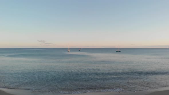 Moored boats on sea at sunset. Aerial forward