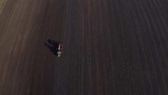 Aerial View Of Harvest Fields. Tractor Driving Across The Field