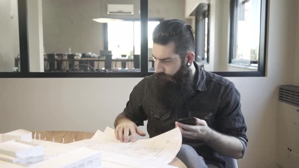 Architect examining blueprints and architectural model