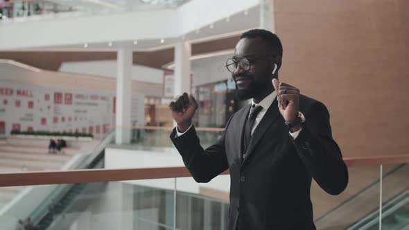 Carefree Businessman Dancing in Mall