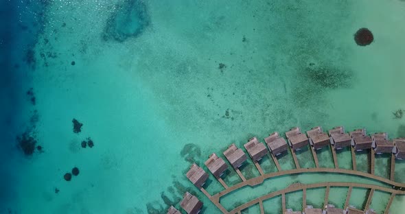 Natural flying clean view of a white sandy paradise beach and blue ocean background in colourful 4K