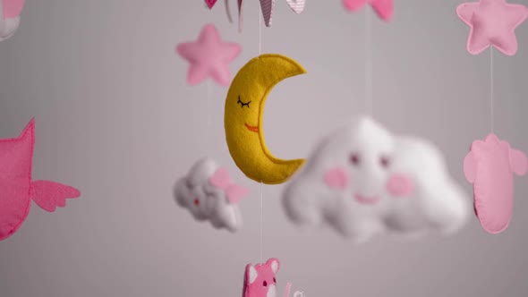 Baby Mobile with Pink Handstitched Animal and Bird Toys with Yellow Moon on White Wall Background