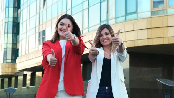 Two Business Women Show Thumbs Up Sign. Successful Completion of the Working Day, Successfully