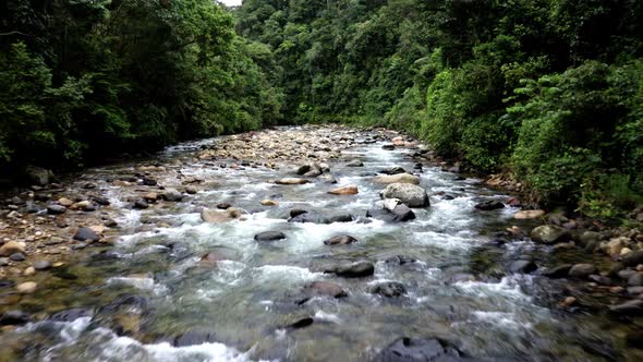 Flying over a tropical river in the Andes of Ecuador with a fast current