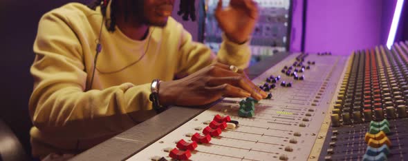 African American Man Working at Mixing Desk in Recording Studio