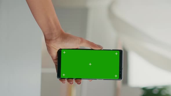 Vertical Video Back View of Freelencer Holding Chroma Key Green Screen Mock Up Smartphone