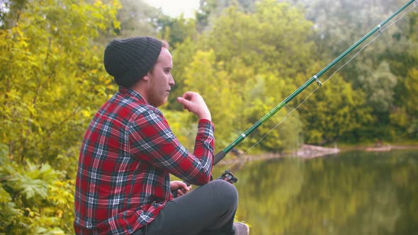 Sad Young Man on Fishing - Holding the Fishing Rod and Looking at Water