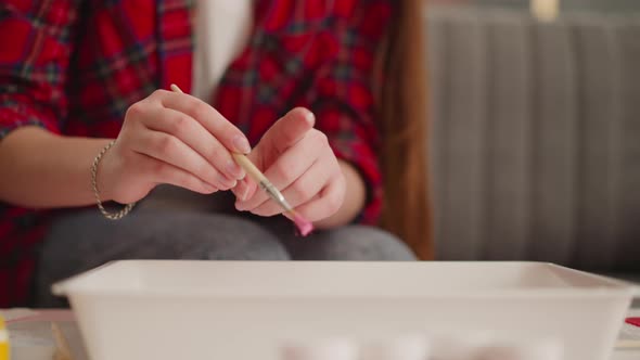 Artist Shakes Off Drops of Pink Paint Into Water in Workshop