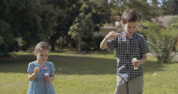 Slow motion of a kids blowing soap bubbles outdoors