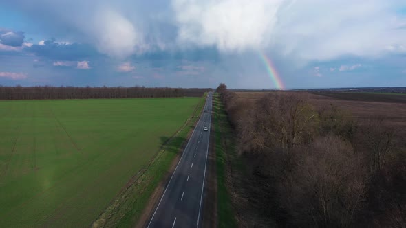 Sun-Shower With Rainbow Over the Highway