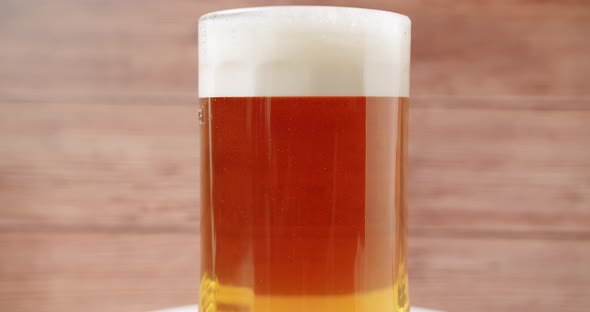 Craft Full Beer Into the Large Glass Beer Mug On a Wooden Background