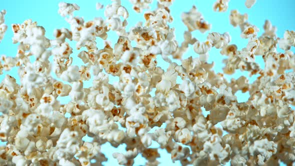 Super Slow Motion Shot of Popcorn on Blue Background After Being Exploded at 1000Fps