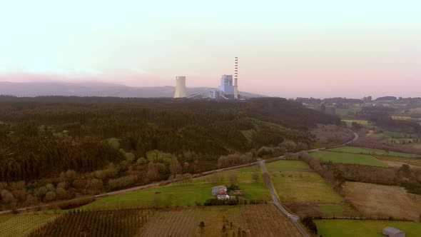 Aerial View Of Meirama Thermal Power Plant Seen In Distant Background Against Pink Skies. Dolly Left