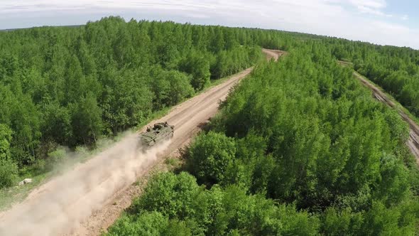 Flying Over Military Vehicle on Dirt Road in Woodland