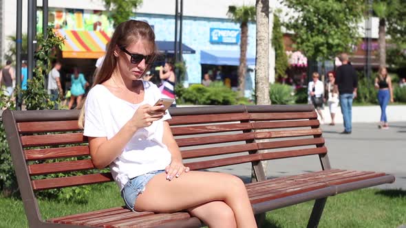 Girl Use Phone on the Bench