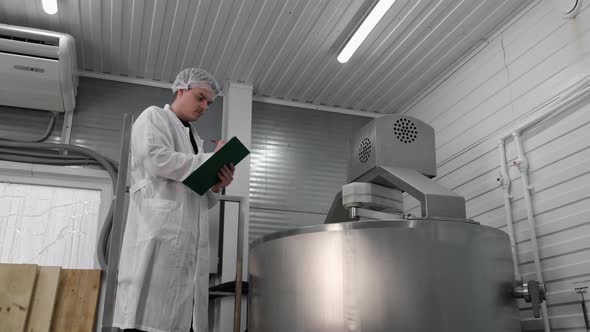 Cheese Technologist Makes Notes on the Quality of Production