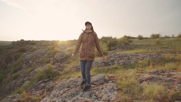 A Young Woman Traveler Walks in the Mountains at Canyon