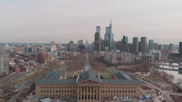 Aerial over Art Museum in Philadelphia facing downtown skyline with traffic driving on roads