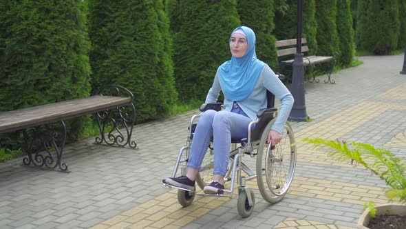 Young Arab Woman Disabled with Glasses and Traditional Scarf in a Wheelchair