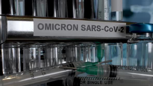Test tubes named B.1.1.529 are being placed into a metal tube rack labeled with OMICRON SARV-COV-02.