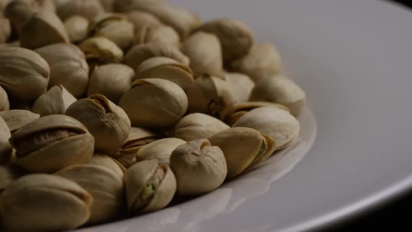 Cinematic, rotating shot of pistachios on a white surface - PISTACHIOS 040