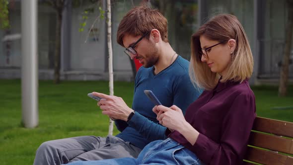 Young couple friends using smartphones outdoor park,