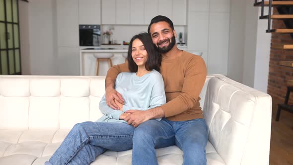 Cheerful Smiling Indian Couple in Love Sitting on the Comfortable Sofa