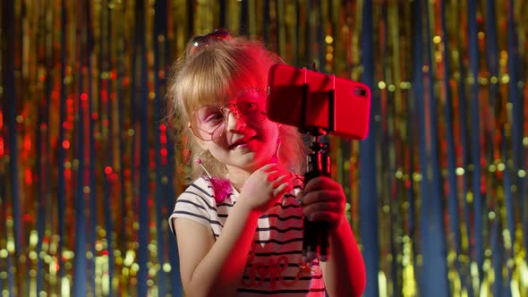 Fashion Girl in Futuristic Night Club with Red Neon Lights Making Video Call Selfie on Mobile Phone