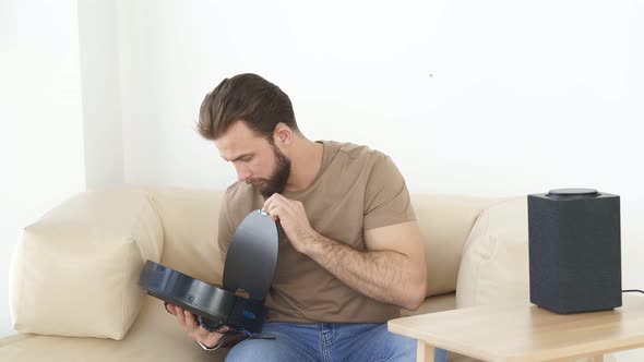 Young Bearded Man is Going to Empty the Deposit of an Automatic Vacuum