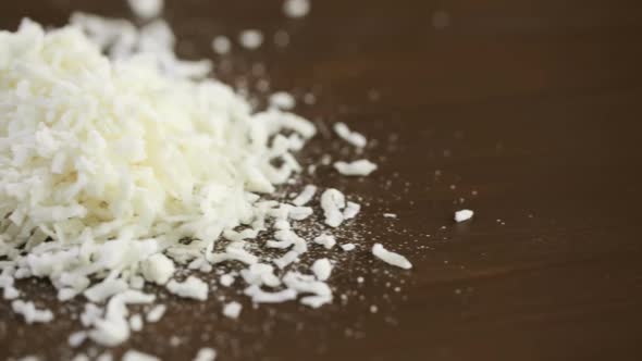 Dehydrated coconut flakes on a wood background.