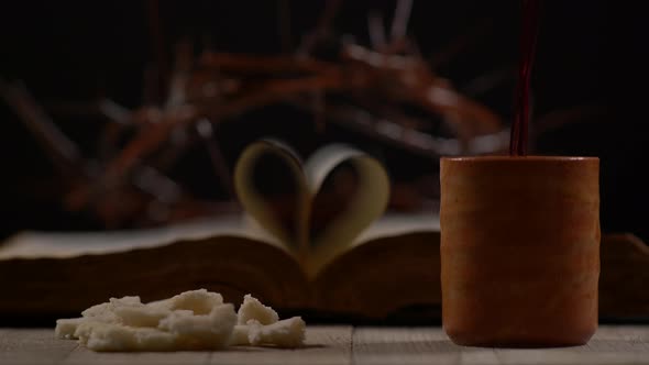 Wine Being Poured Beside Bread With Bible And Crown In Background, Shallow Dof