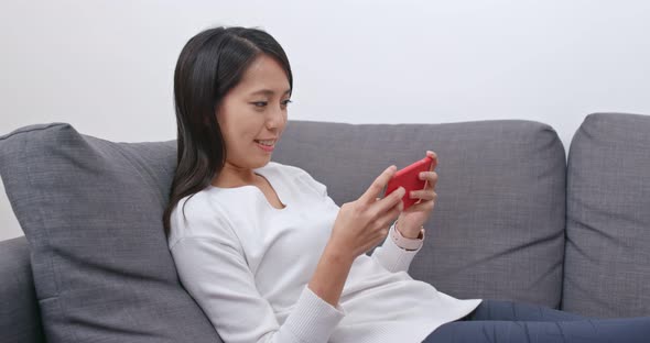 Woman play on cellphone at home