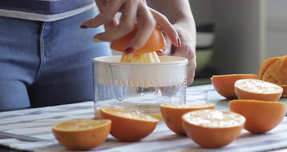 Woman squeezing orange juice in kitchen