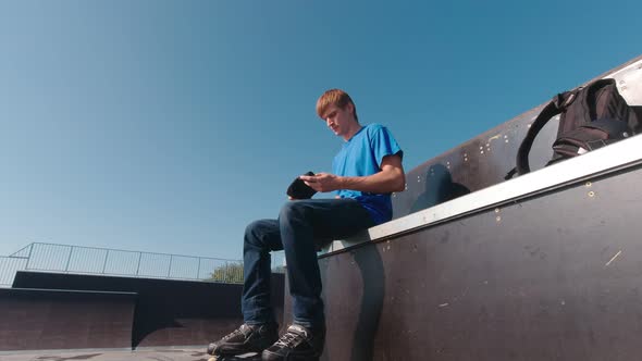 Man Putting On Protection In Skate Park