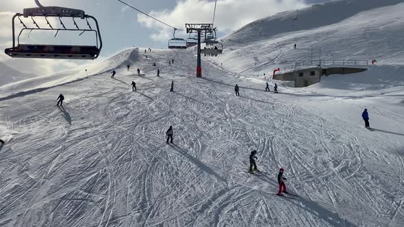 People skiing on snowy slope at ski resort in the mountains