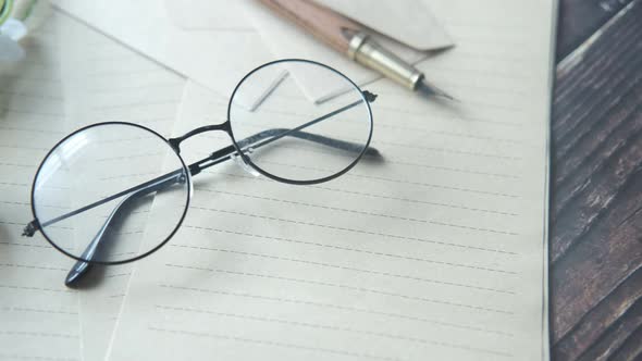 Notepad Eyeglass and a Pencil on Wooden Table