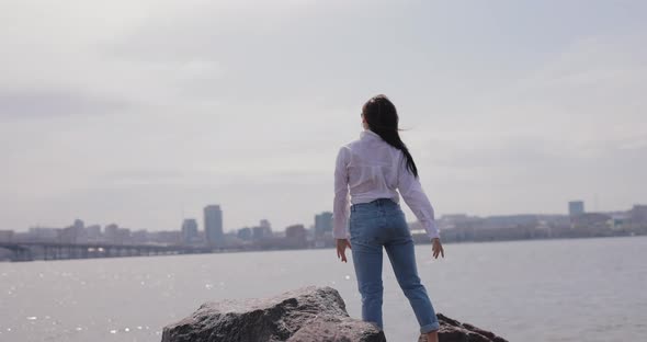 Happy Woman Standing on the Stone with Raised Hands