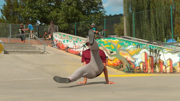 Man breakdancing in a skate park, slow motion alt