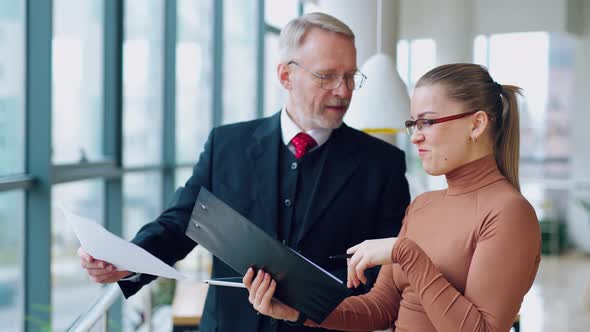 Smiling secretary talking to a mature business man