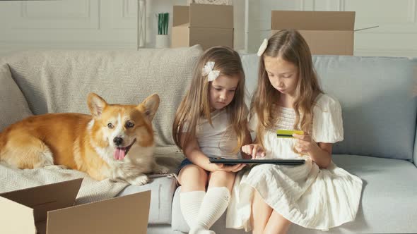 Two Children Working on a Laptop at Home and Do Some Operation With a Credit Card